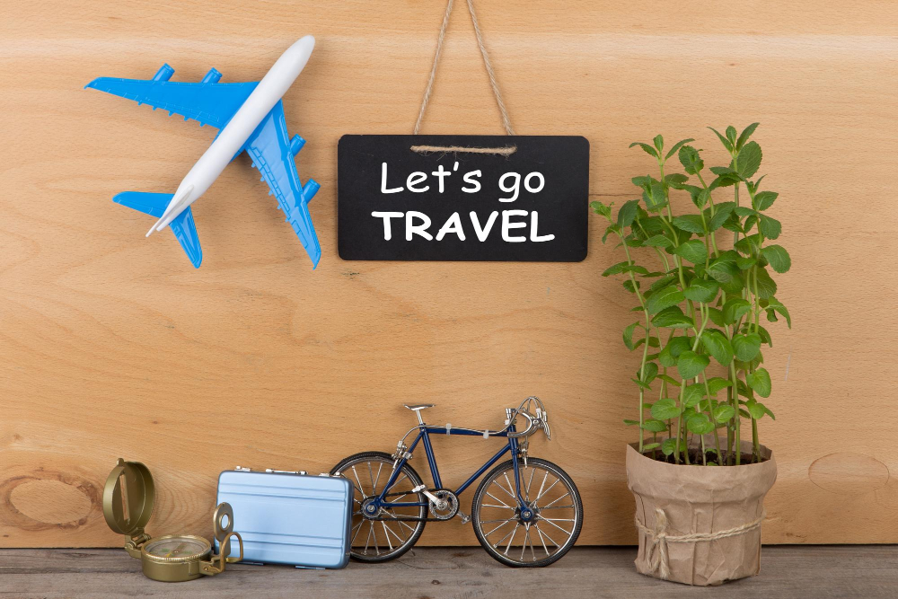 travel time concept blackboard with text let s go travel airplane model little bicycle suitcase